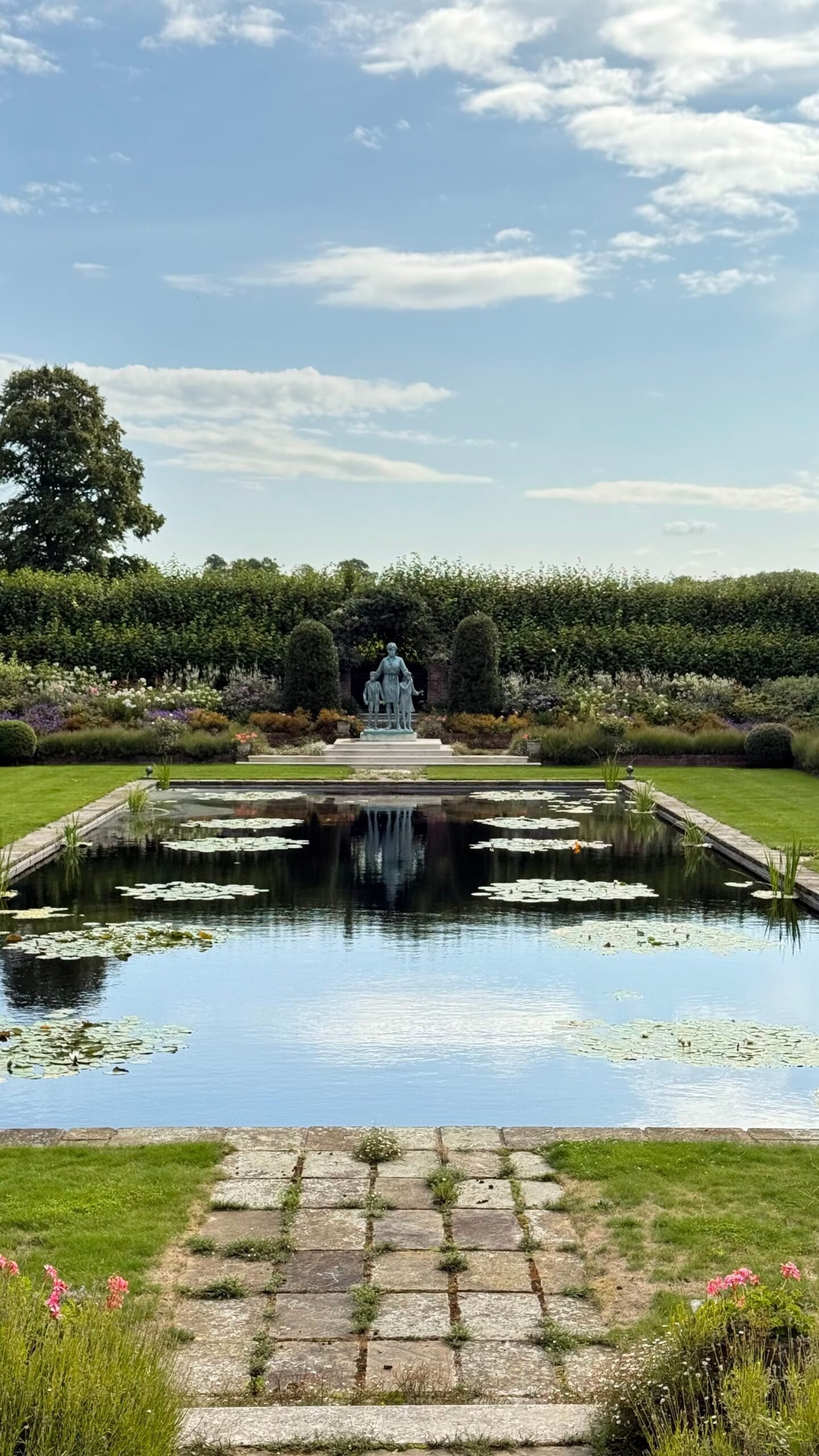 Formal London garden with a lily pond, statue and clipped hedges