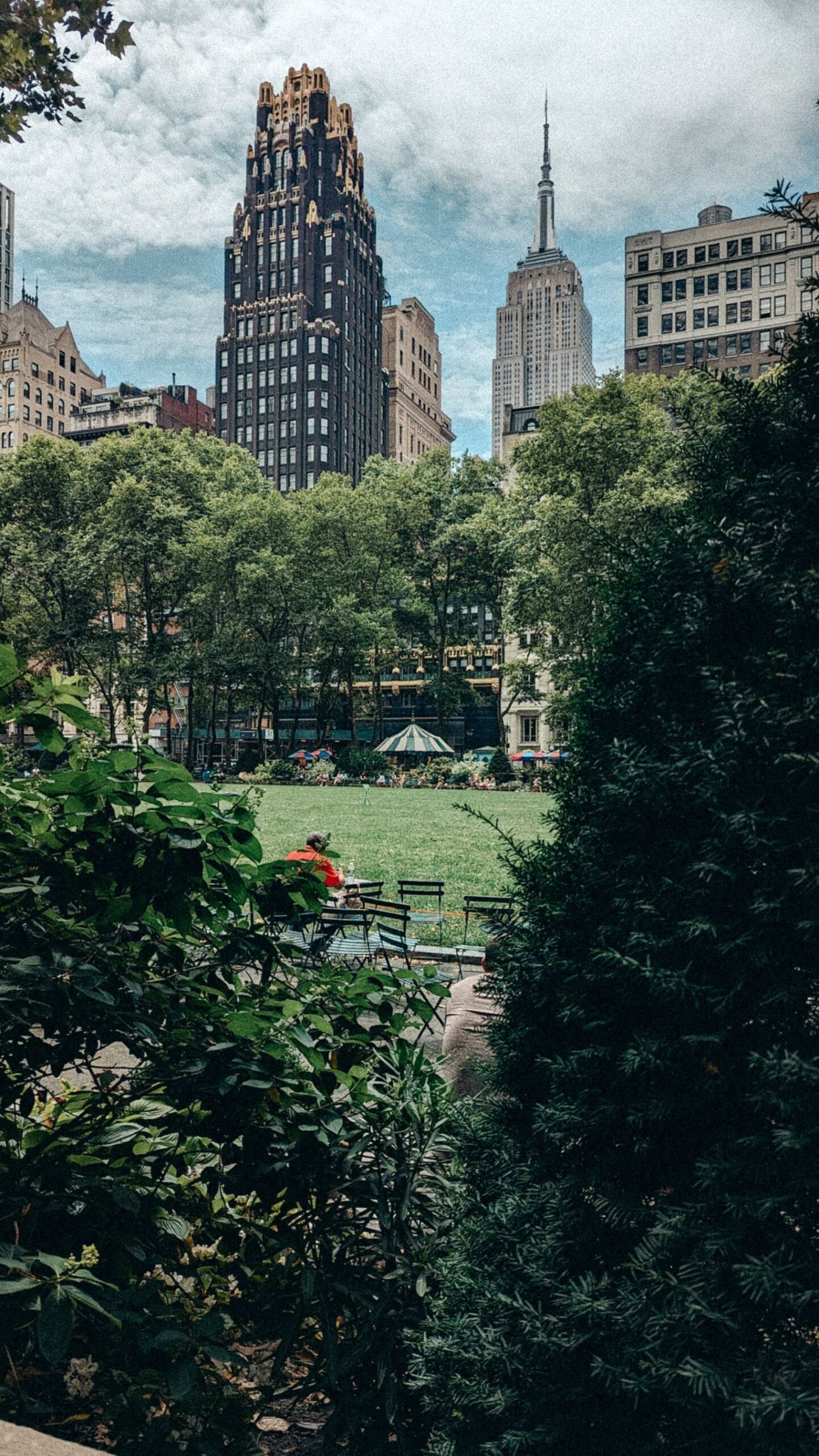 Leafy New York City park with the Empire State Building behind the trees